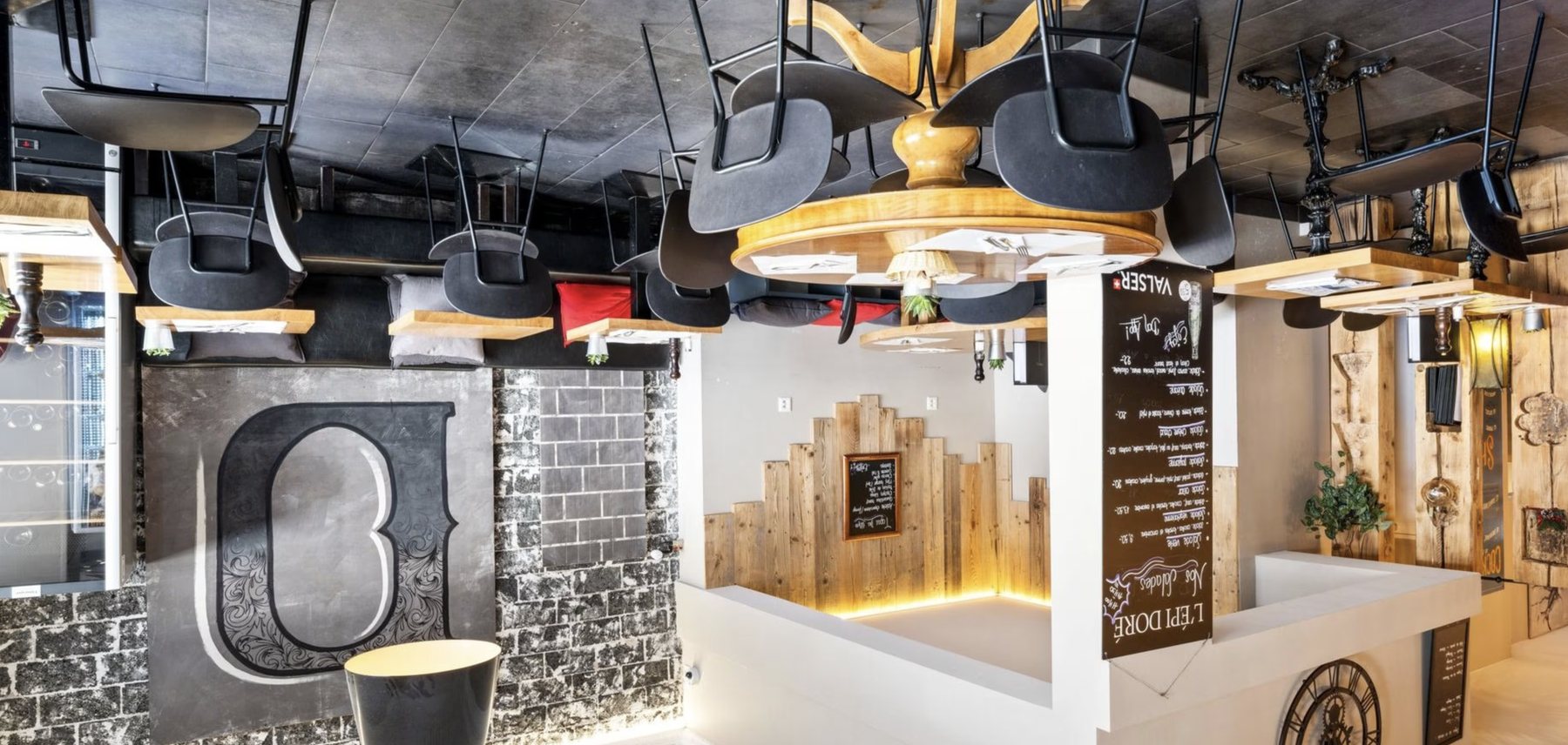 Salle du restaurant, tables en bois et banquettes.